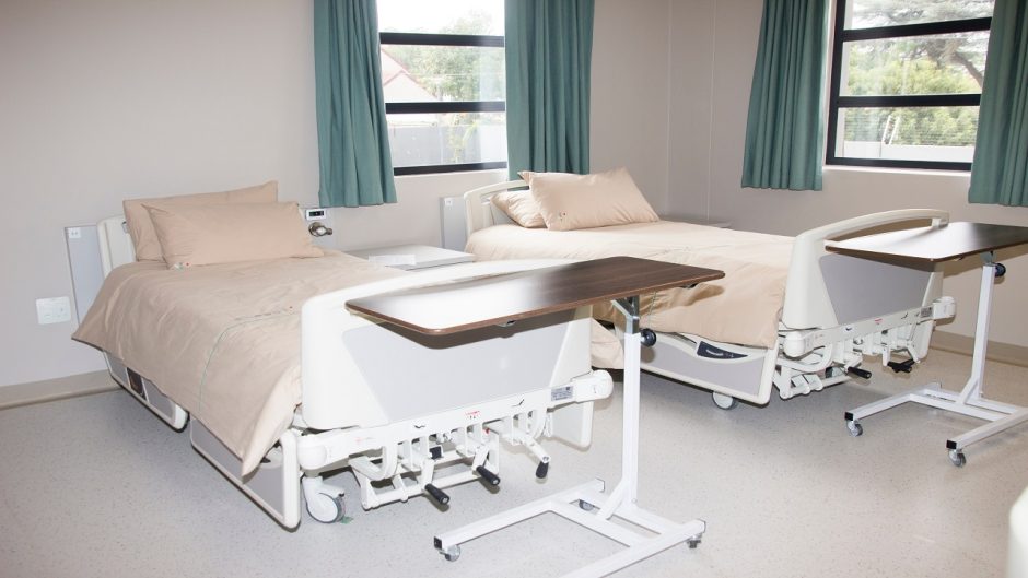 Two beds in empty hospital room.