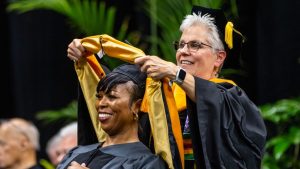 Nancy Birtley hooding a graduate student at commencement